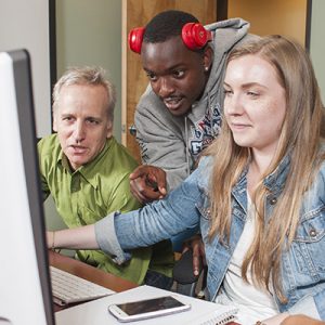 Southern Oregon University Students and Professor Working on Computer