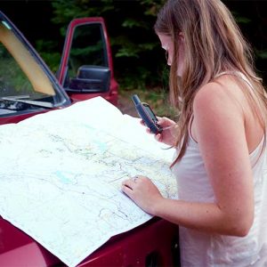 Environmental Science Student Looking at Map and GPS