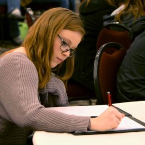 Female Economics Student Taking Notes In Class