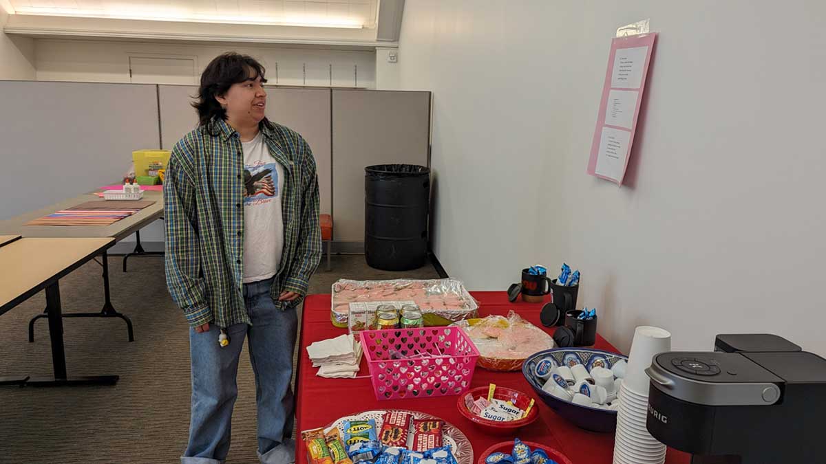 Student at the Valentine's Day celebration with table full of snacks