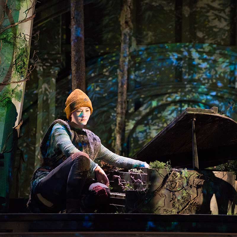 Actor in Forest Attire Kneeling on Stage