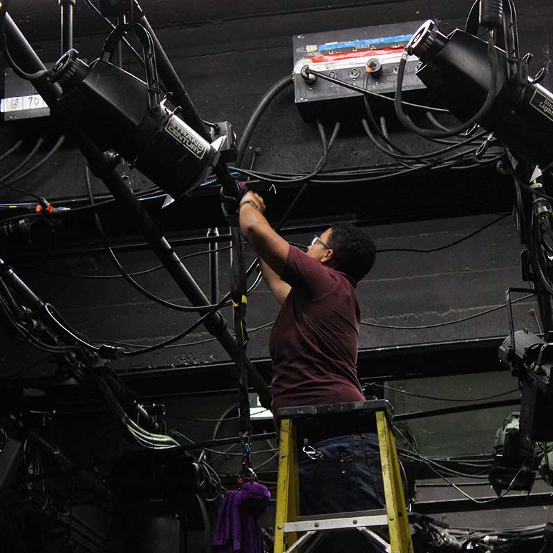 Student Working on Lights on Ladder