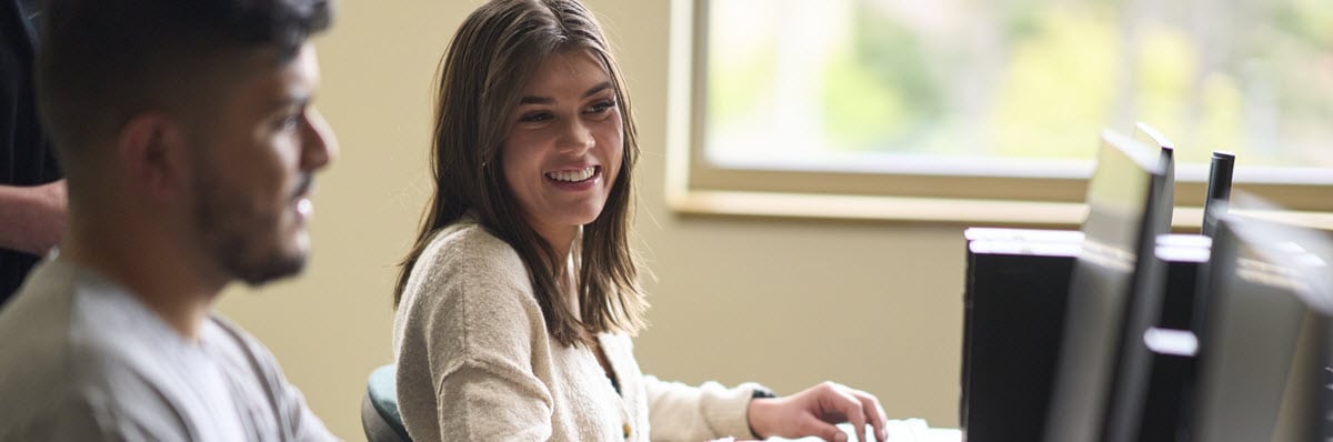 Two students looking at a computer monitor